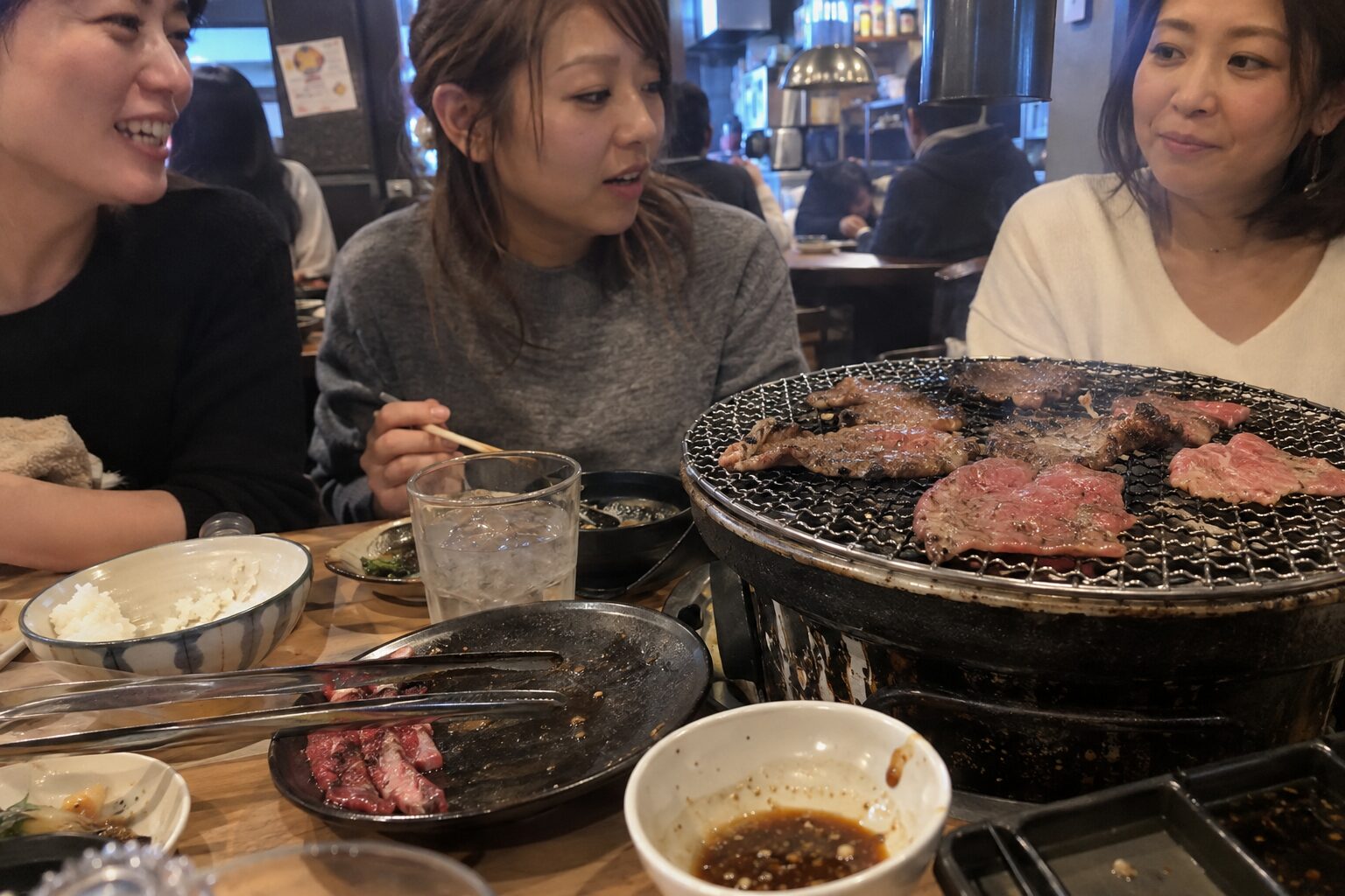 焼肉を囲み、好みを話しながら楽しむ3人の女性