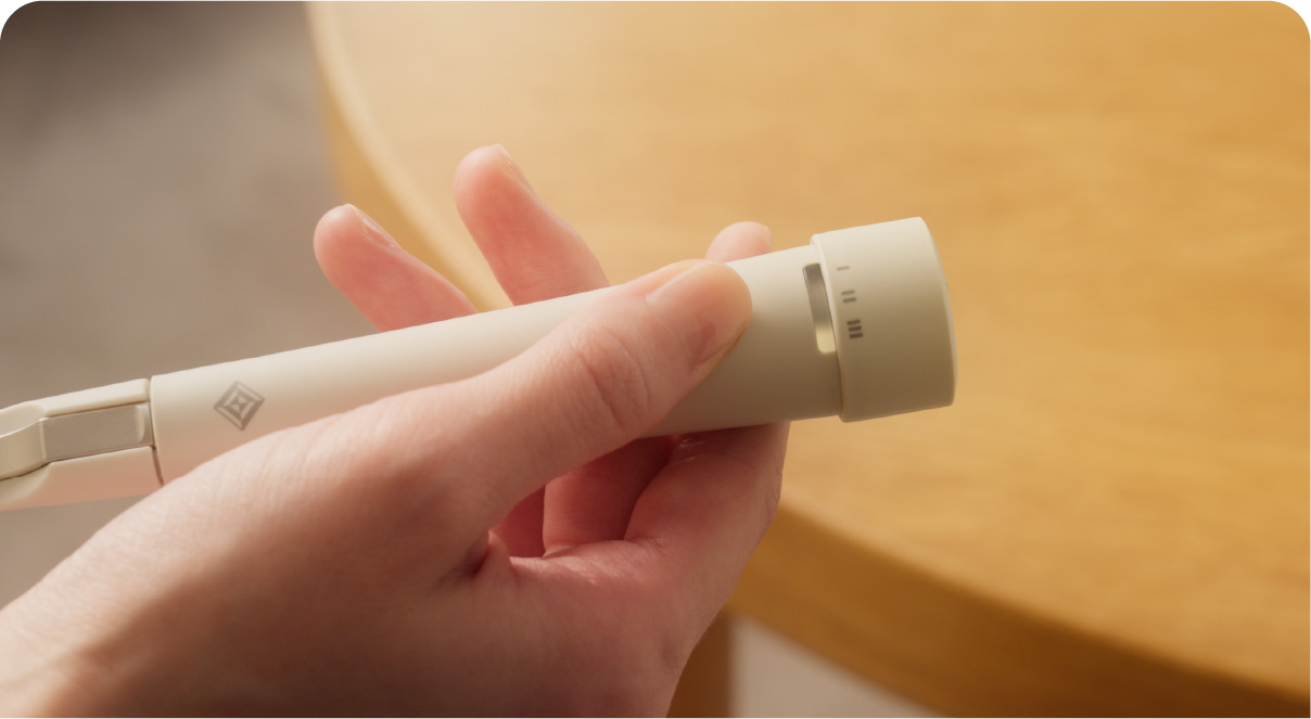 エレキソルト スプーンの持ち手のスイッチを押す様子